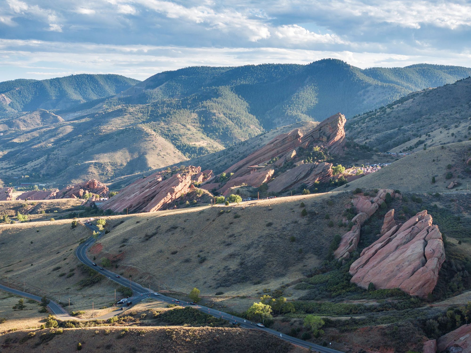 Aerial view of red sandstone formations in Red Rocks Park above a winding road